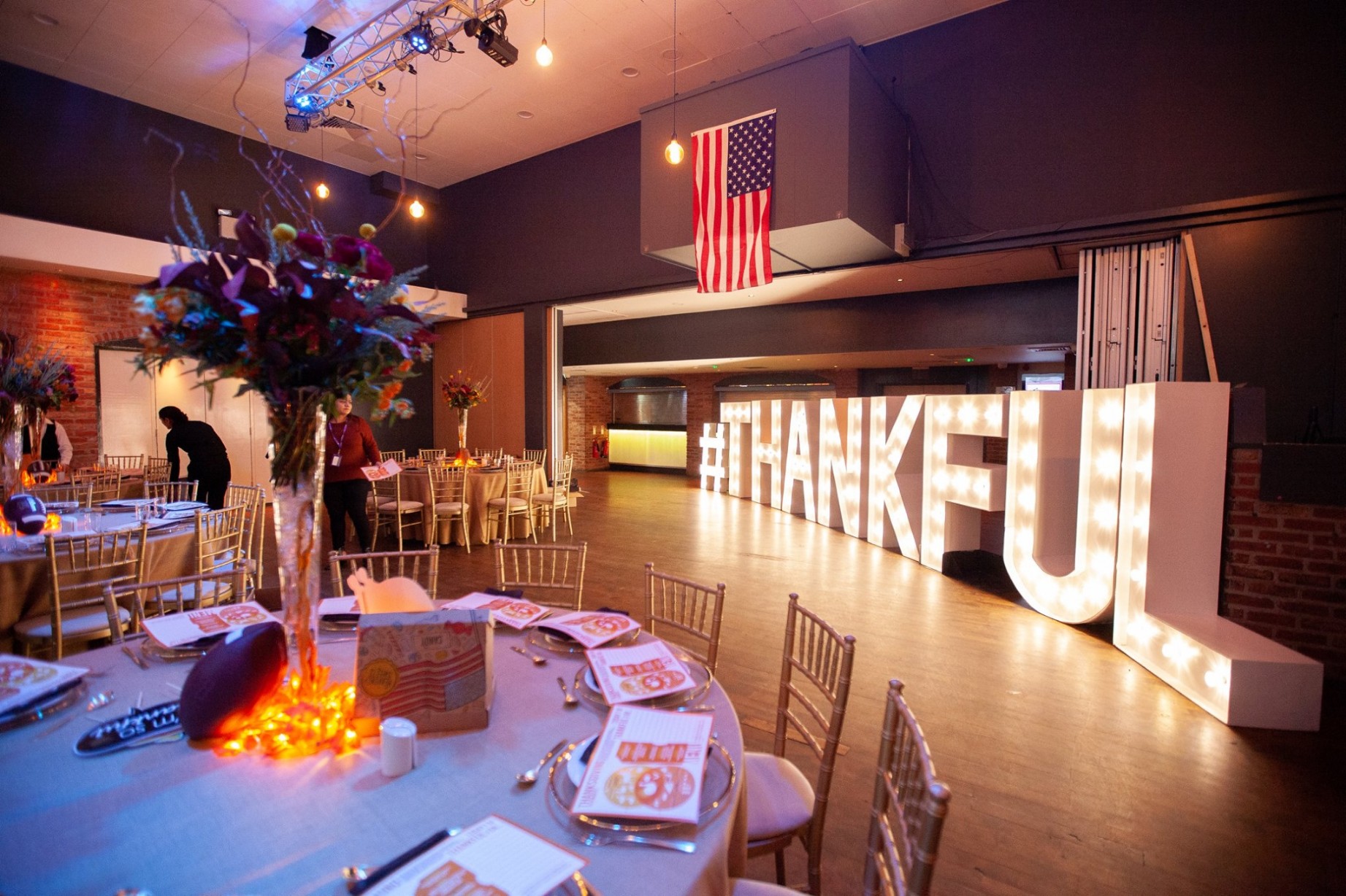 Event space at ISH Venues featuring an American flag and a large illuminated 'THANKFUL' marquee sign.