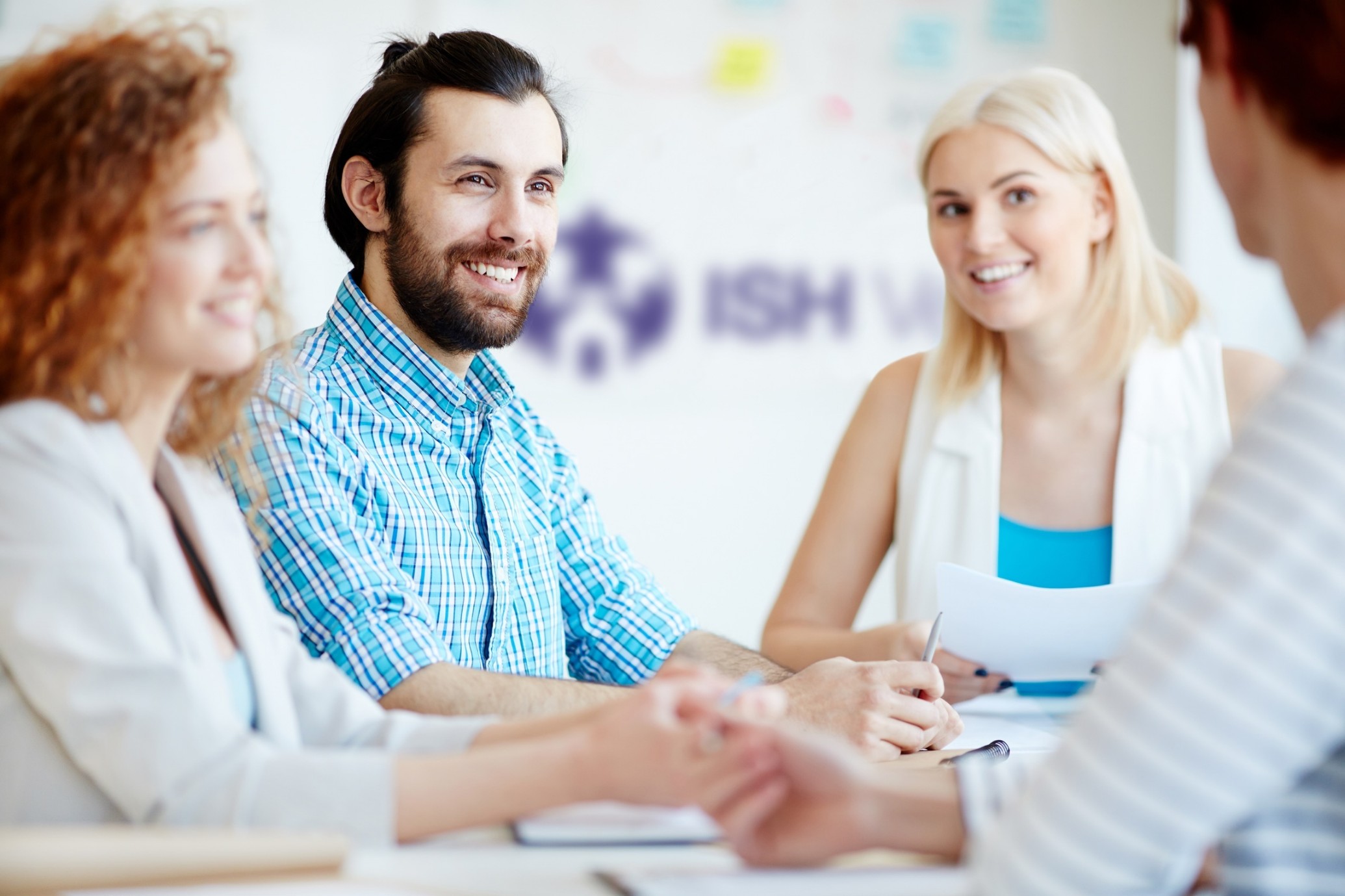 Diverse professionals engaged in a collaborative meeting at ISH Venues, showcasing the room's inviting atmosphere for team-building and networking.