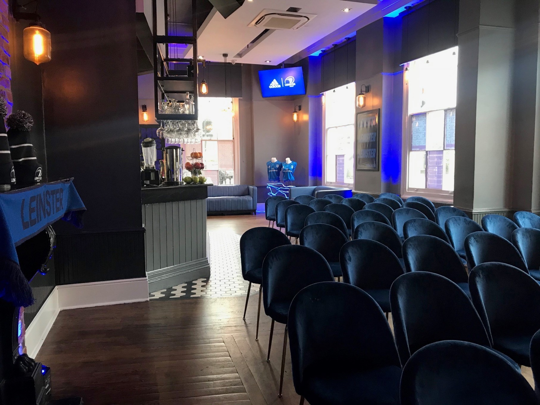 The Thirsty Scholar bar area set with velvet chairs and blue mood lighting, ideal for evening private hire events in Marylebone