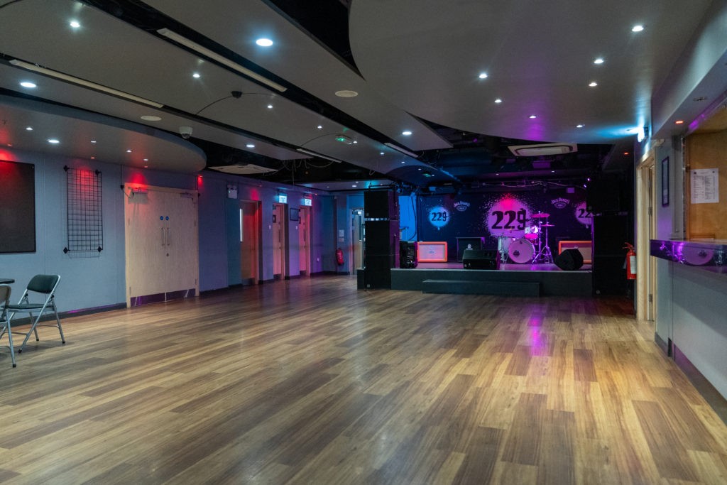 Industrial performance venue at ISH Venues Marylebone with stage, drum kit and atmospheric mood lighting, bookable on Conveenie