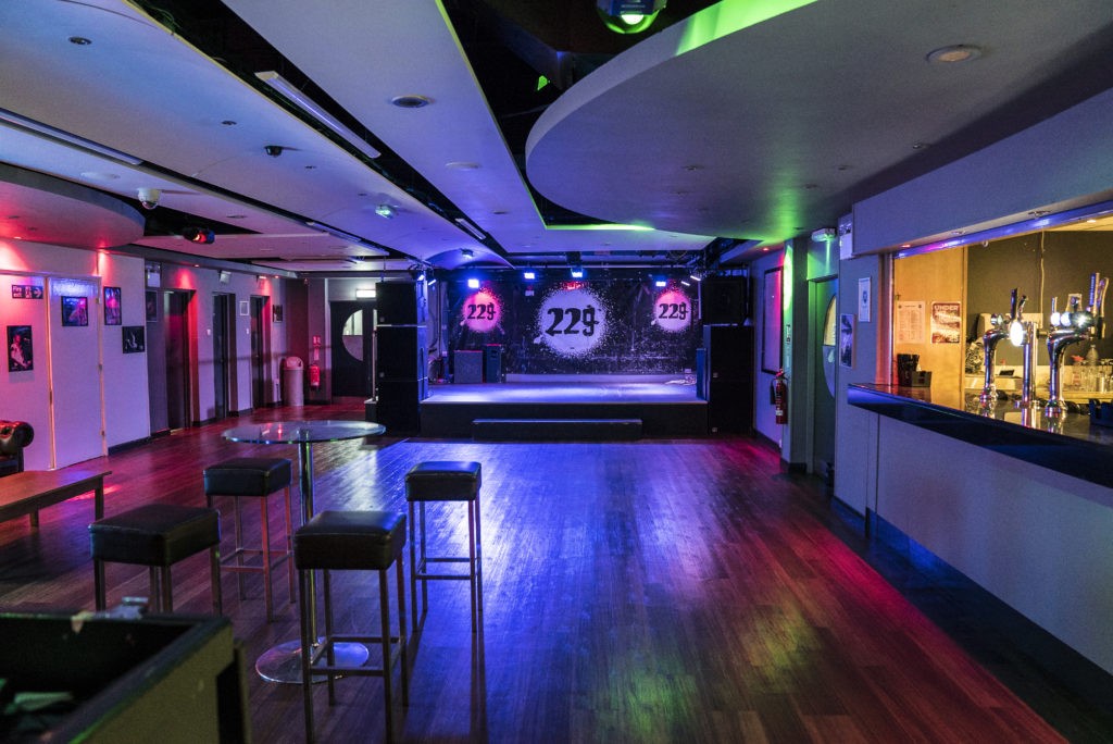 Spacious Marylebone event space with coloured LED lighting and bar stools, perfect for gigs and evening entertainment hire