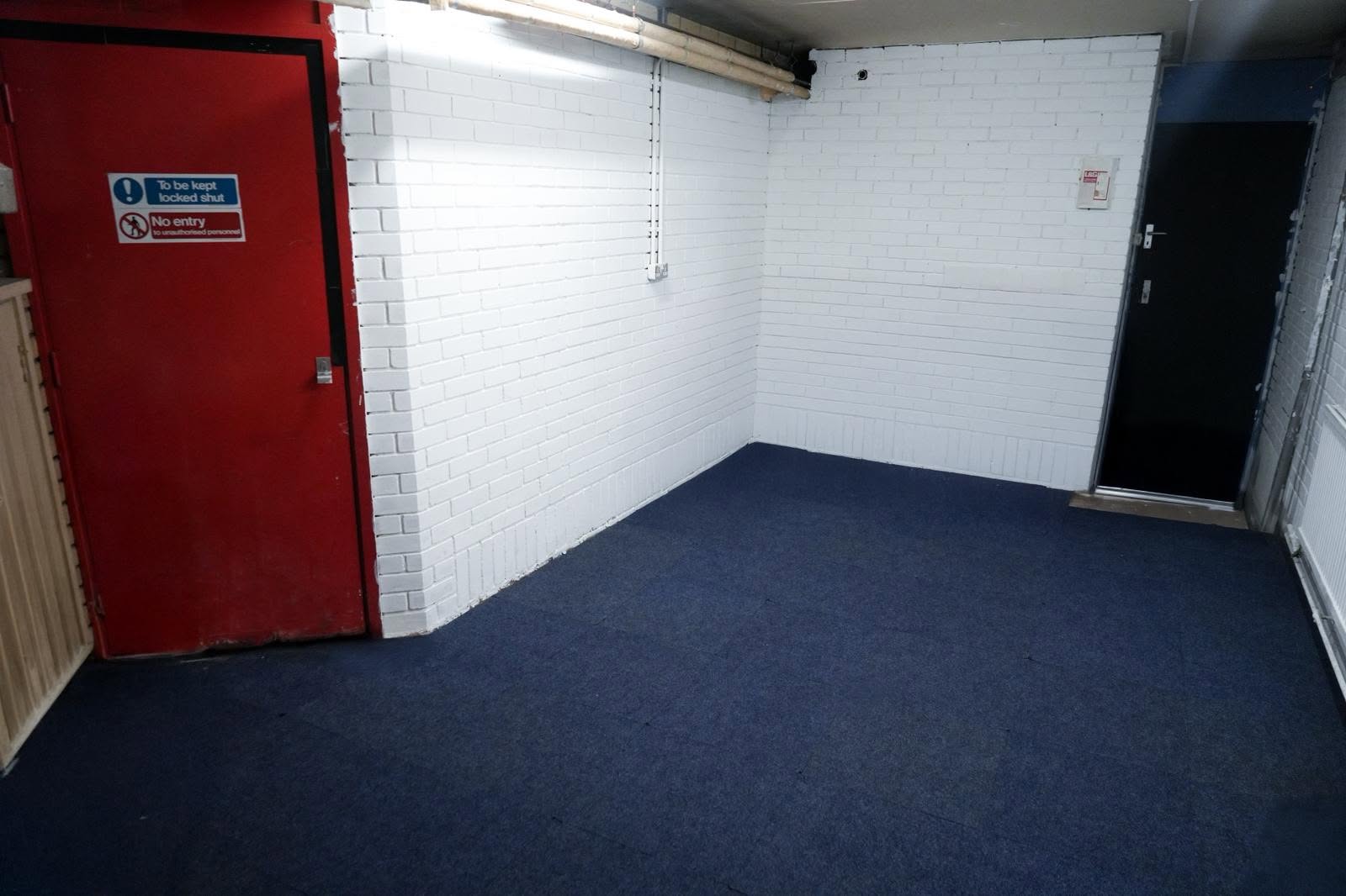 Versatile empty 8-capacity workspace in East London with clean whitewashed brick walls, offering maximum layout flexibility.