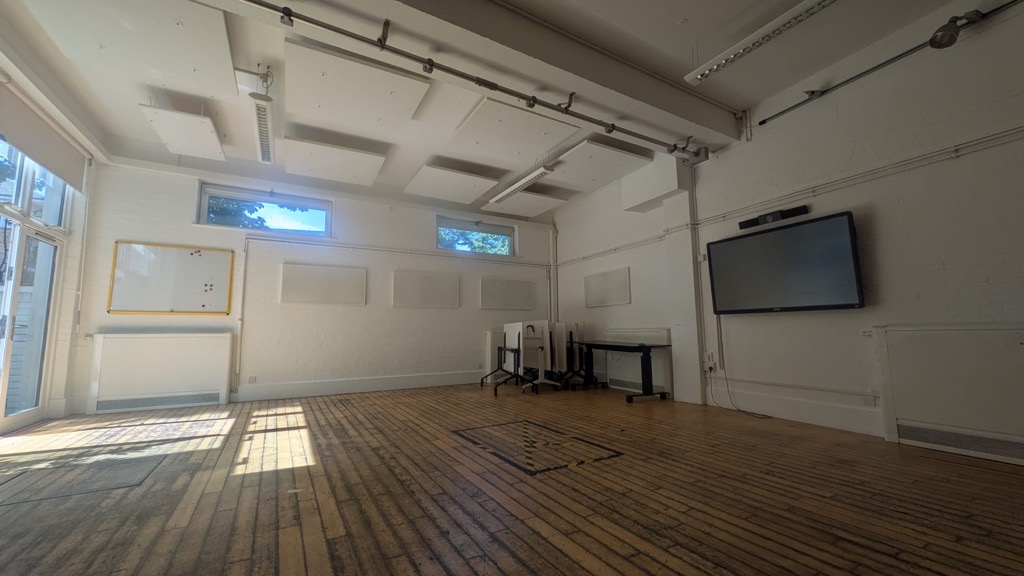 Spacious Main Hall function room at Centre 404 with natural light, wooden flooring and interactive display screen