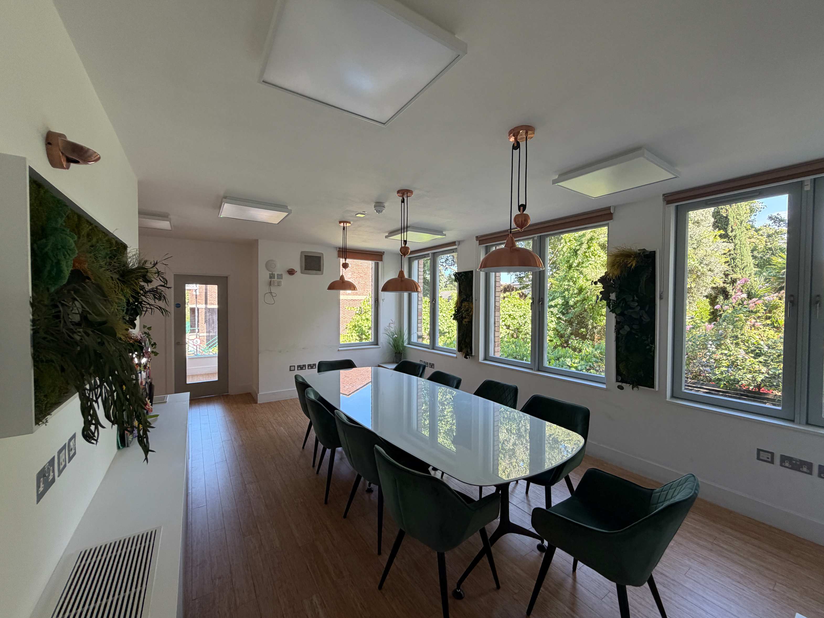 Boardroom at Centre 404 with garden-facing windows and wooden flooring