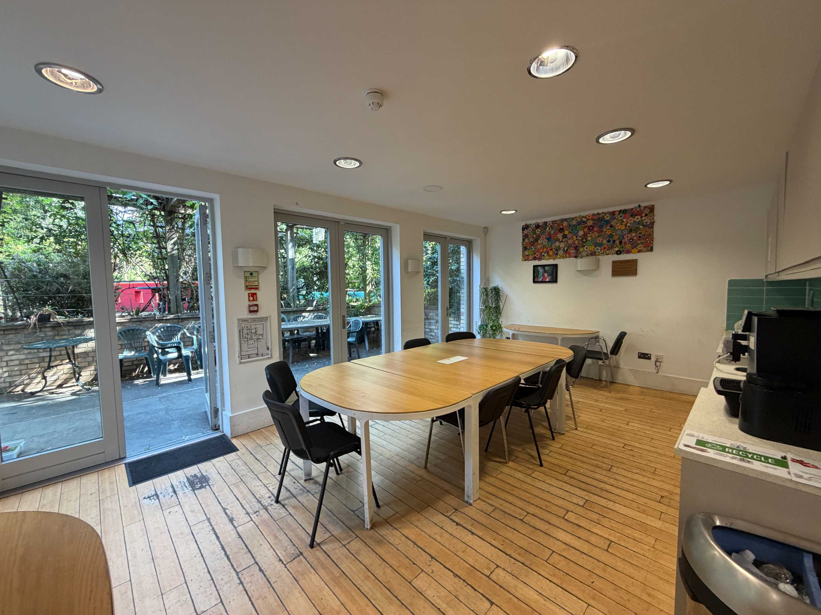 Garden Room at Centre 404 with wooden table, chairs and doors opening onto the garden, London N7