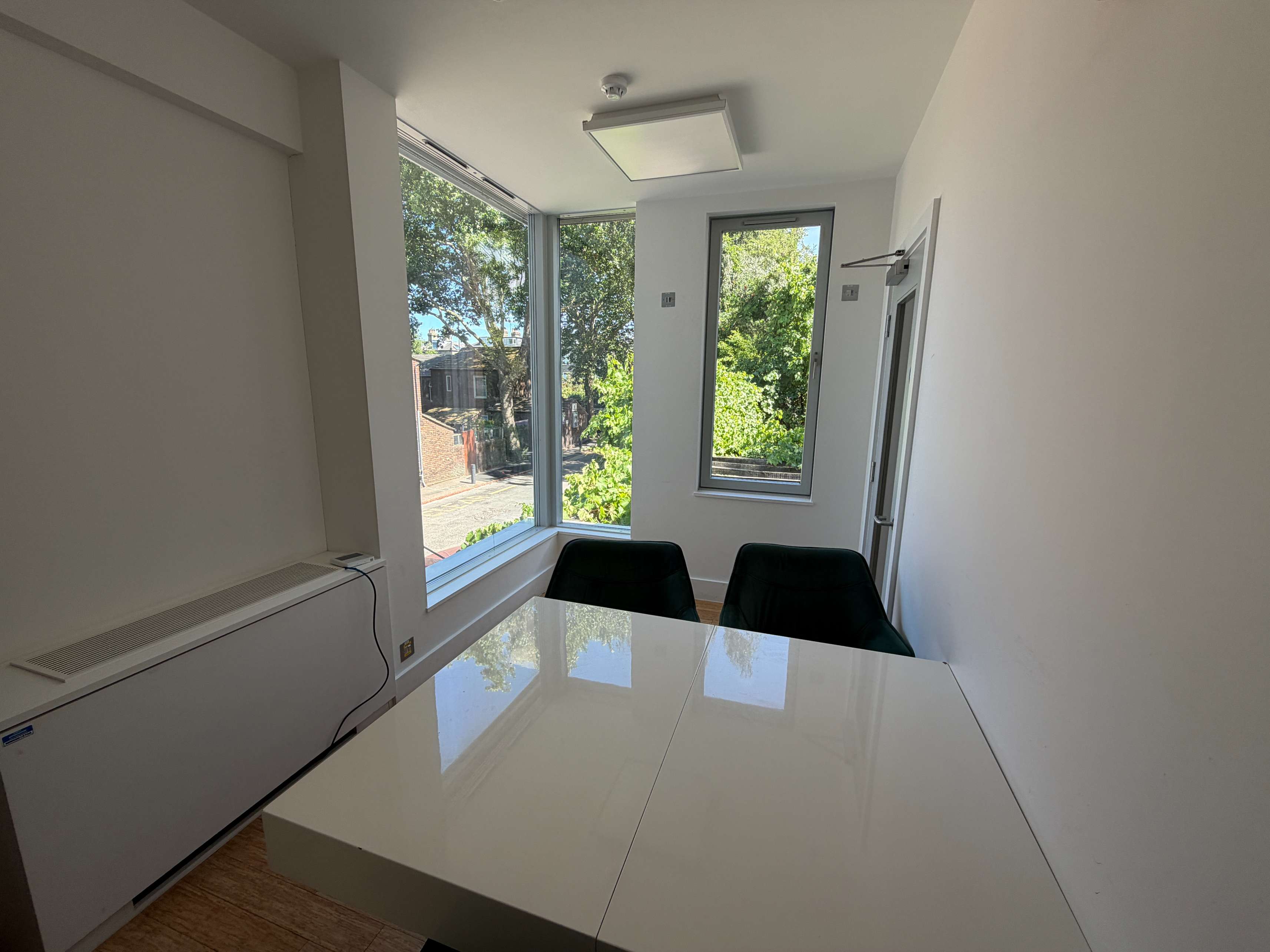 Workspace at Centre 404 with glossy table and floor-to-ceiling windows overlooking trees