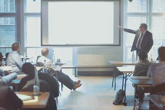 A presenter addresses an audience in the Om Nom Studio event space in Islington, London, suited for seminars, corporate training, and wellness events.