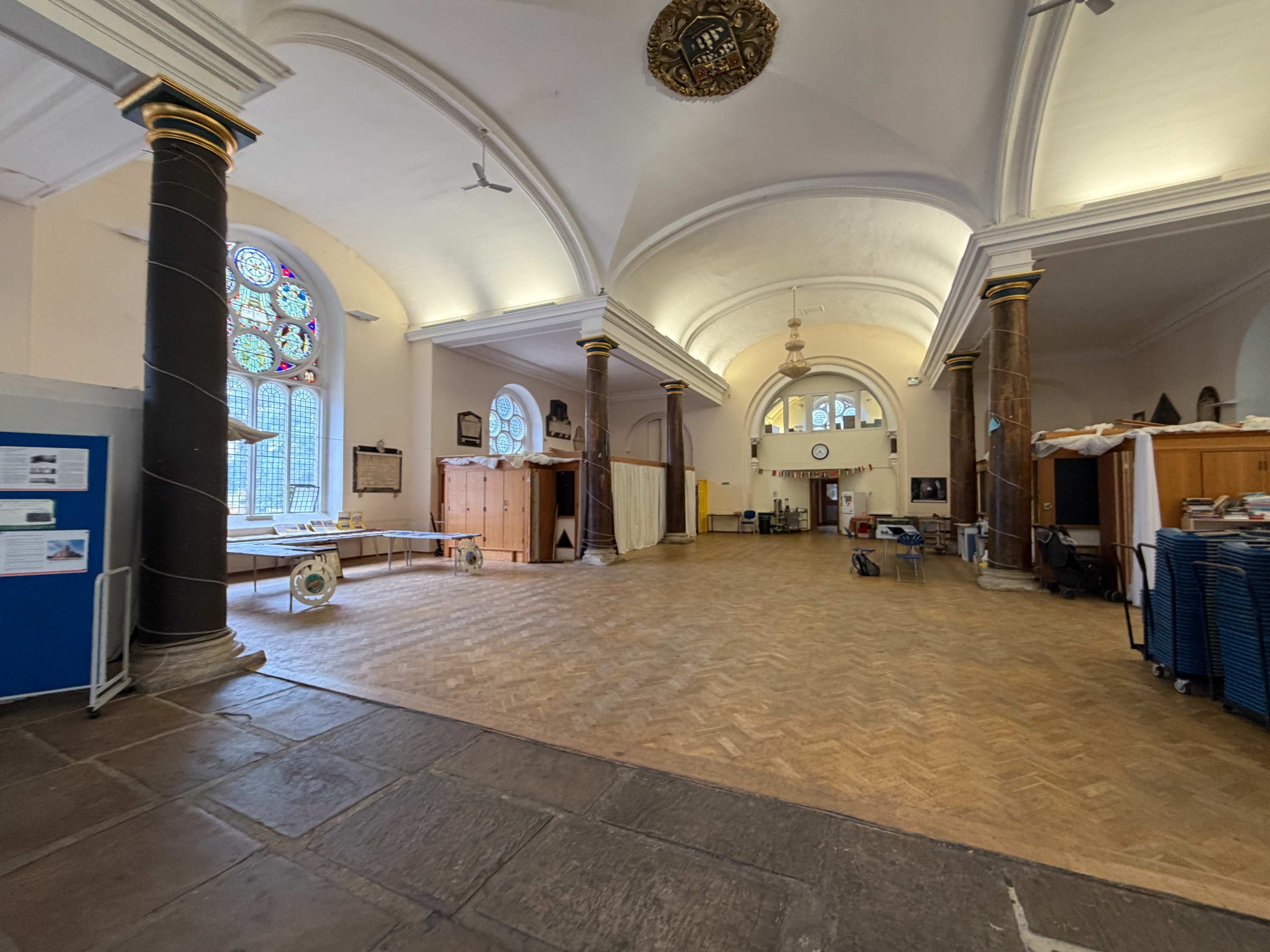 A wide angle view of the interior of St Matthias Church Hall showing the full arched nave, vaulted ceiling, and original stone features, demonstrating
