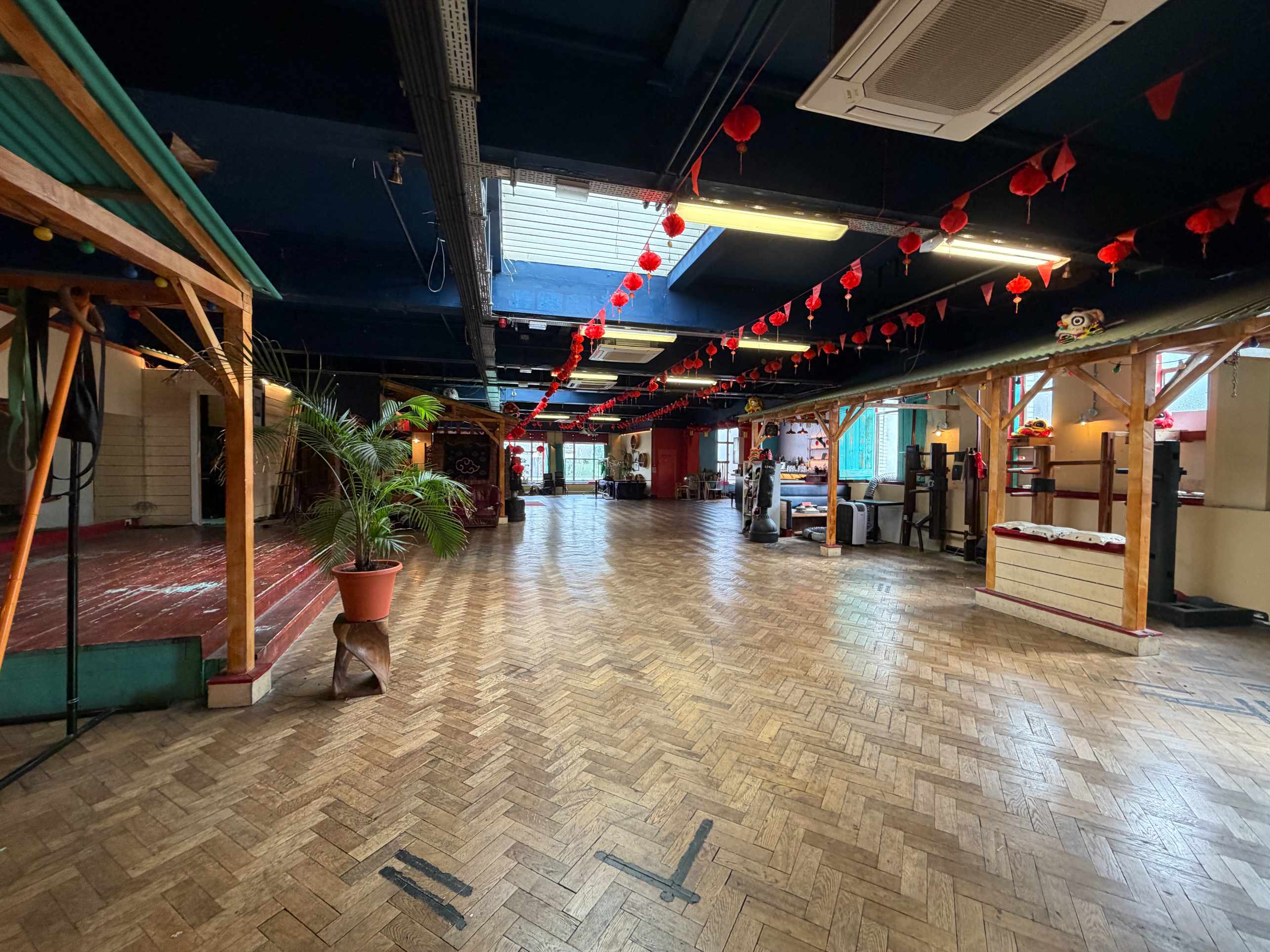 Zhulin Hidden Village London community hall for hire with wooden floor, Chinese lanterns and seating around the open event space