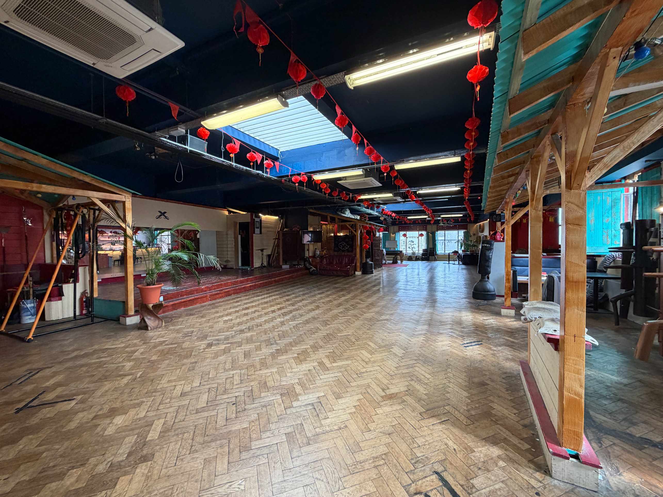 Zhulin Hidden Village London community hall hire with wood floor, red lanterns and tables at the far wall