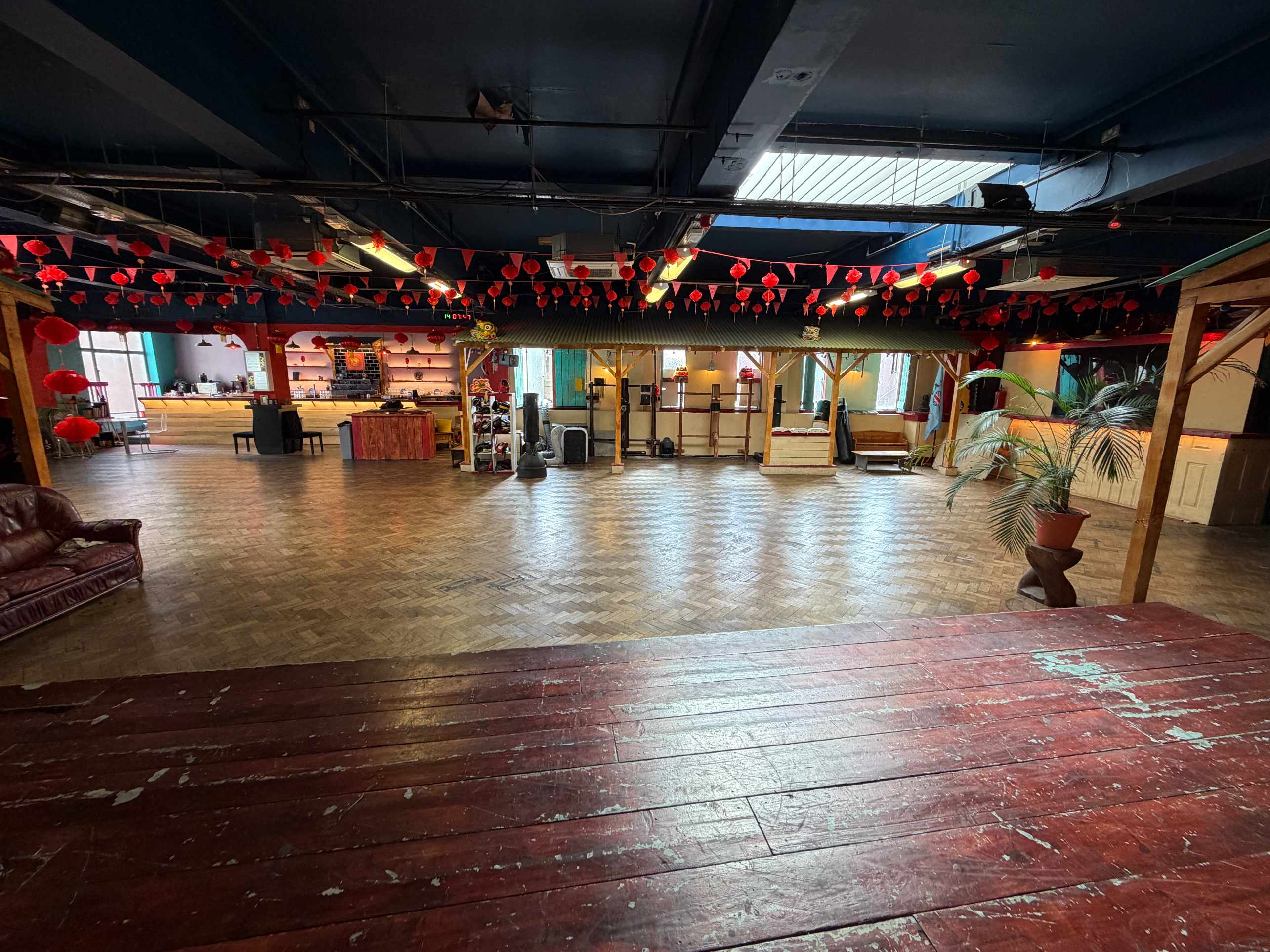 Zhulin Hidden Village London event hall for hire with dark wooden floor, far-end seating and red hanging lanterns
