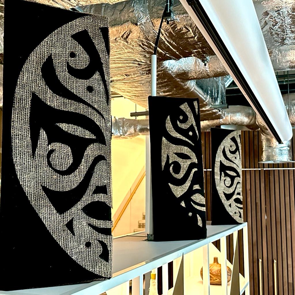 A close-up of the unique, decorative art panels on burlap, part of the stylish interior at the Melanin Health & Wellness Community Centre.
