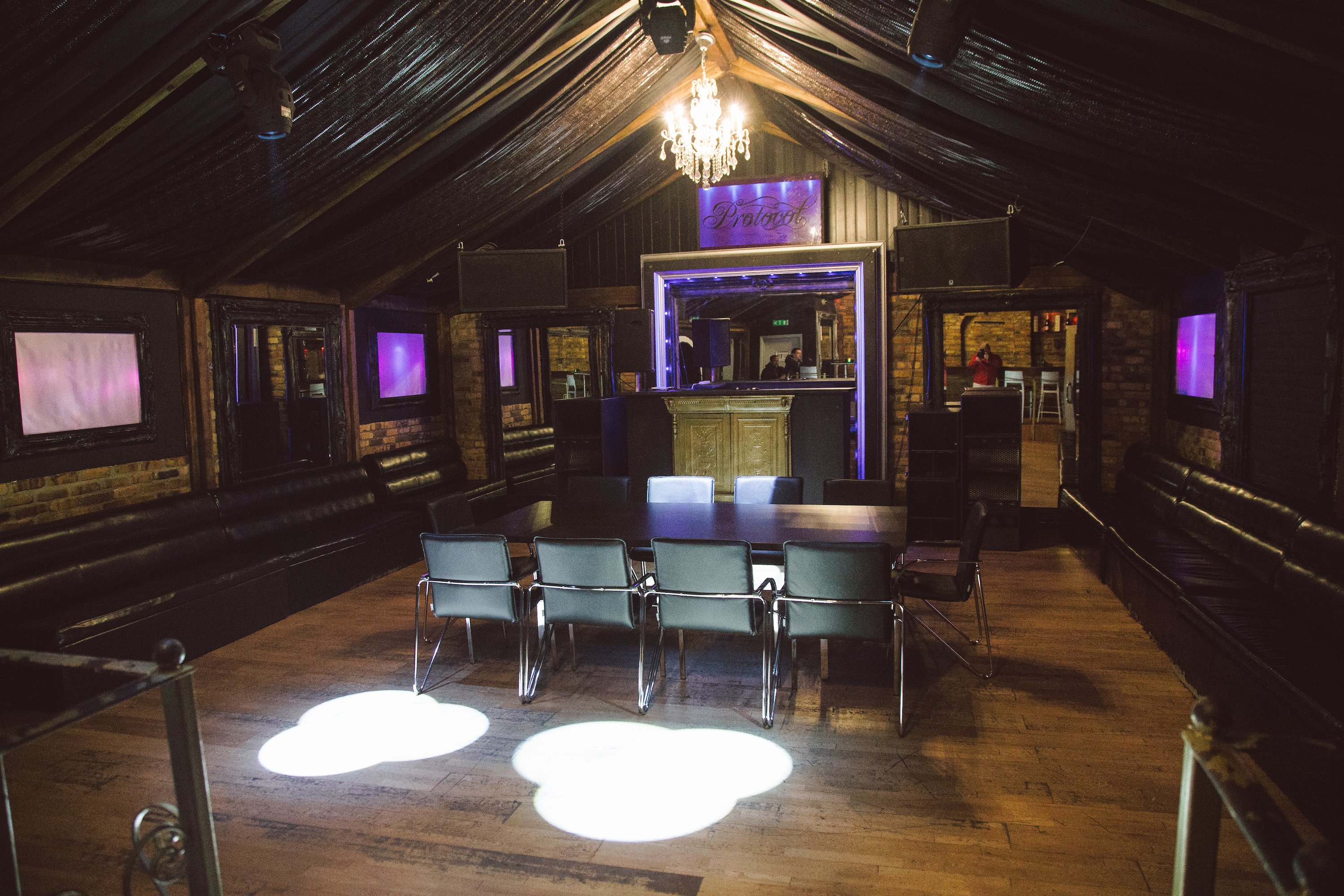 VIP area at Protocol, 350-capacity, with plush white booths in brick alcoves under dramatic purple lighting, book via Conveenie.