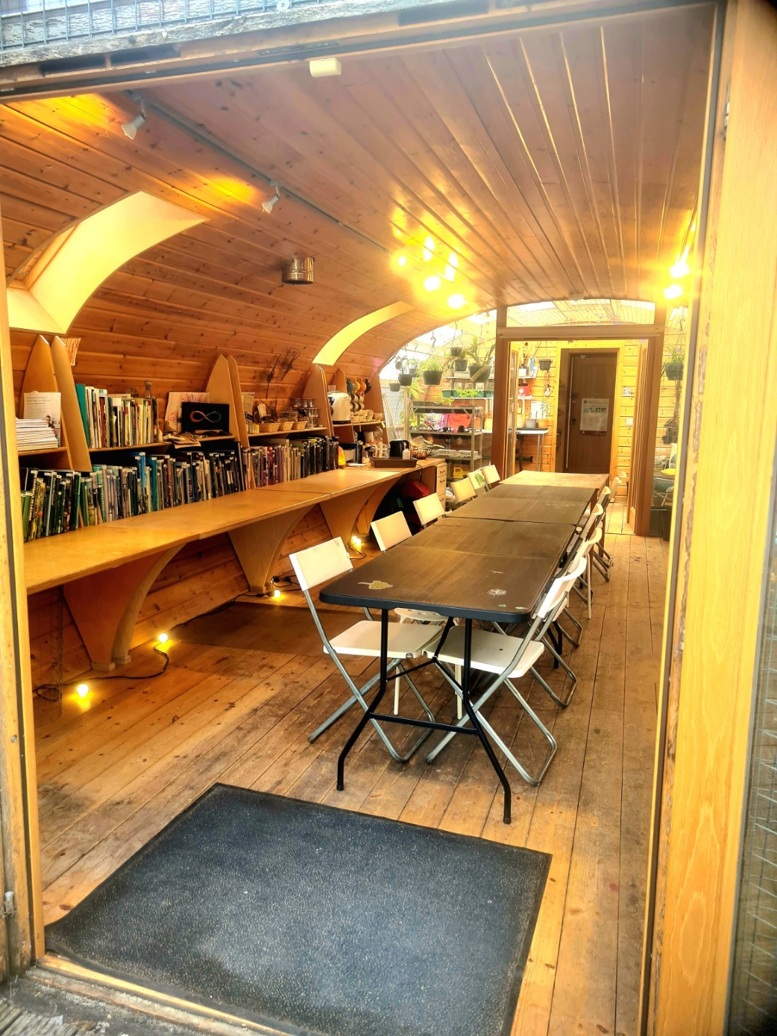 A small wooden studio with a vaulted ceiling, a long meeting table, and shelves of books.