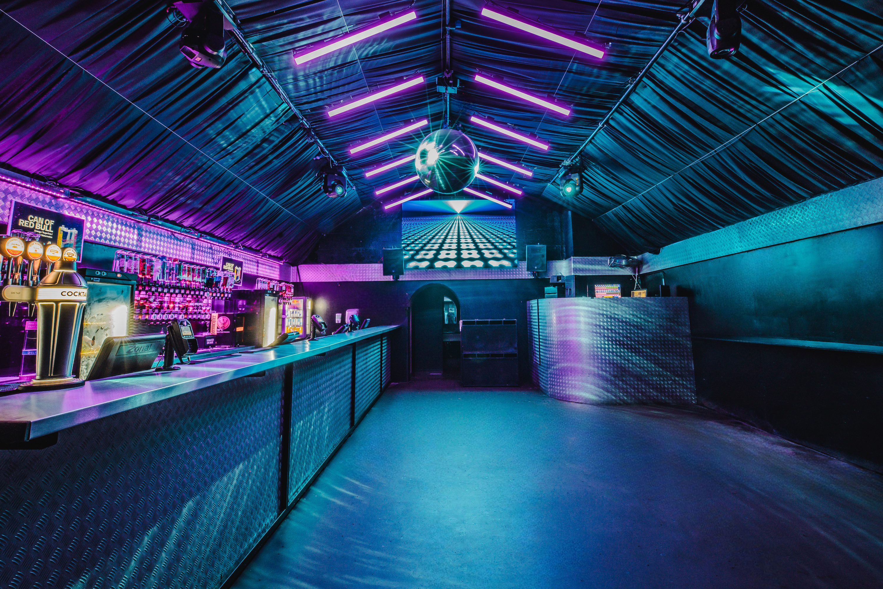 An intimate, warmly-lit bar area at Vauxhall Arches, part of the 600-capacity venue, featuring dark leather booths and polished wooden floors.