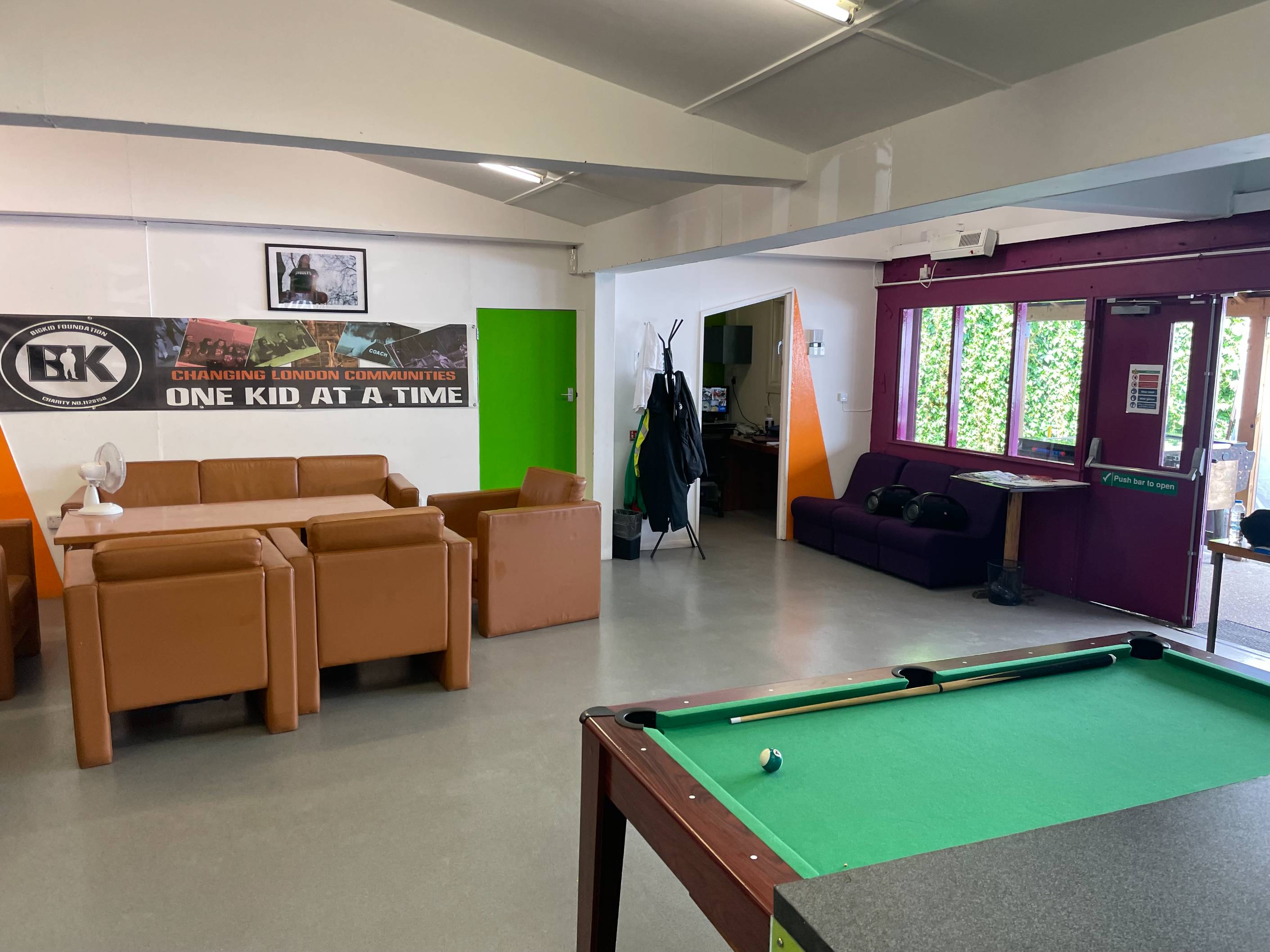 Bright indoor hall at Dexters Adventure Playground with sofas, pool table and seating for up to 30 guests