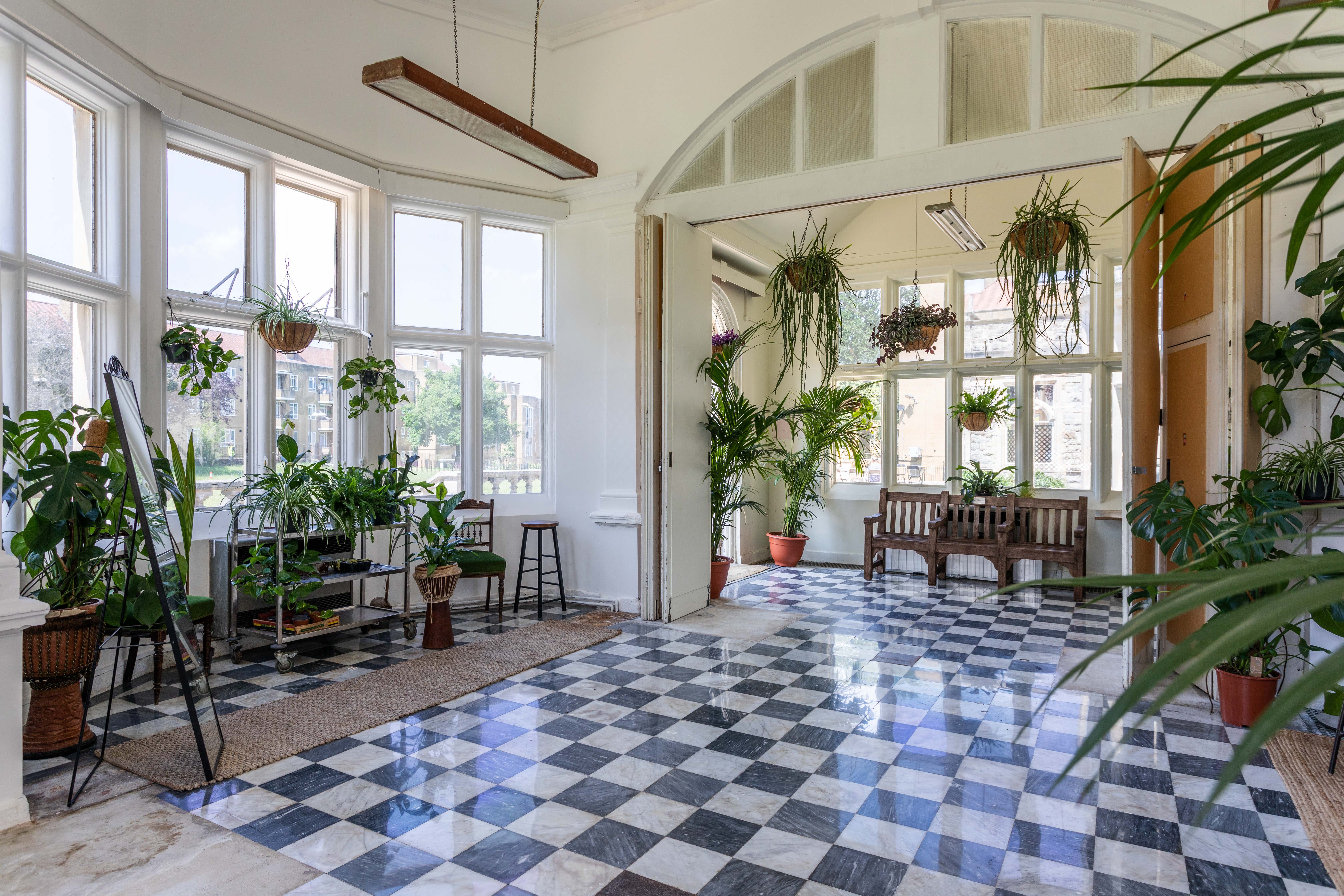 Palm Court at Kingswood Arts, 40-capacity, with high vaulted ceiling, arched windows, and reflective checkered floor, book via Conveenie.