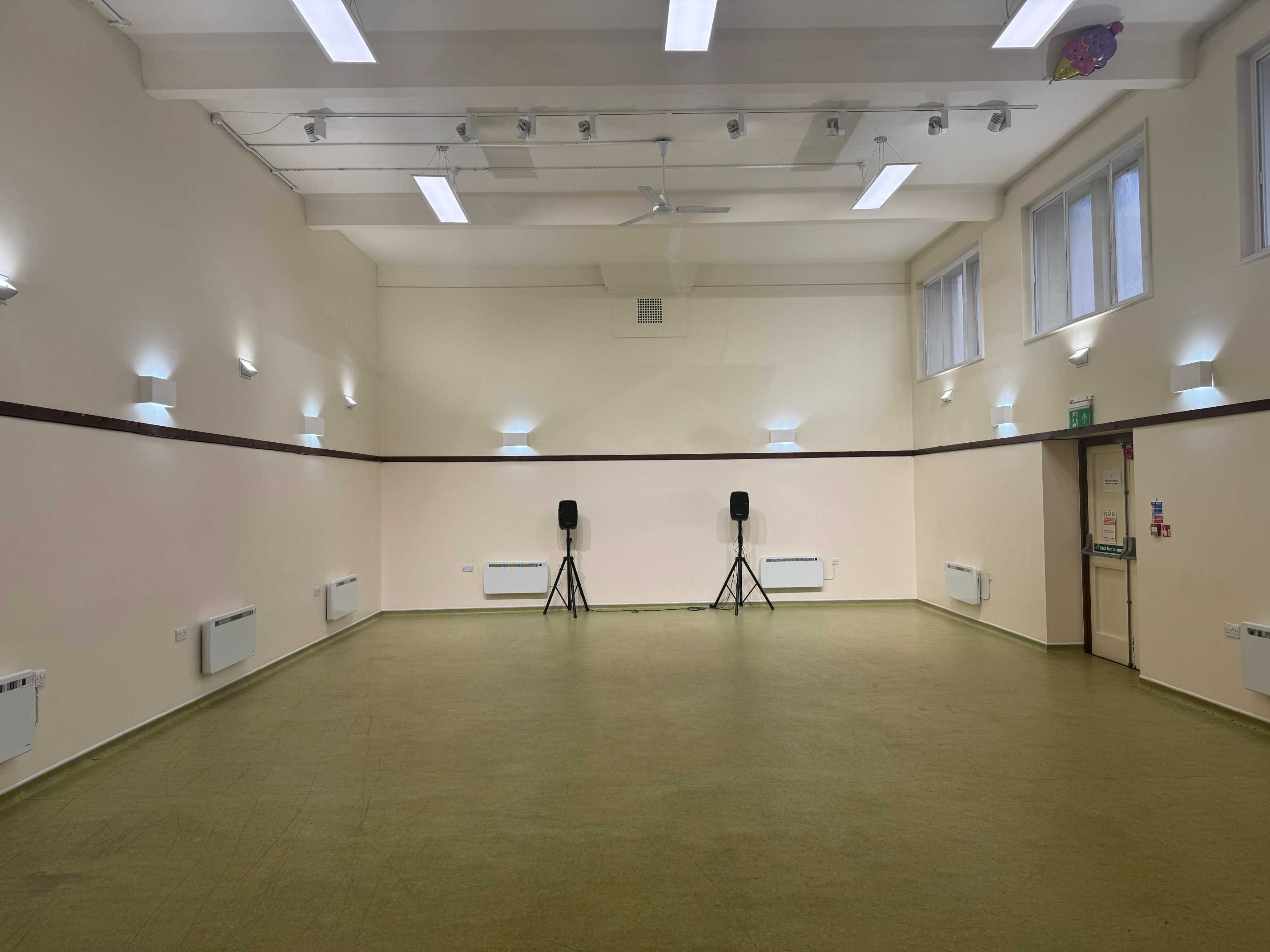 Warm ambient lighting with uplights and wall lights creates a welcoming vibe for events at St John's Centre