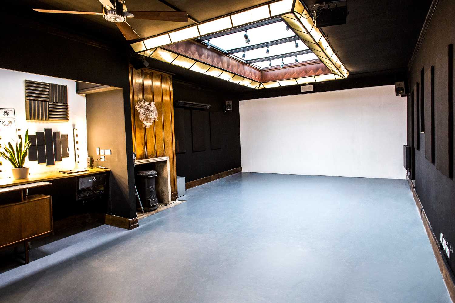 The Home at Anomalous Space in London, a unique event space hire london with a large skylight, screen, and dark, creative decor for 80 people.