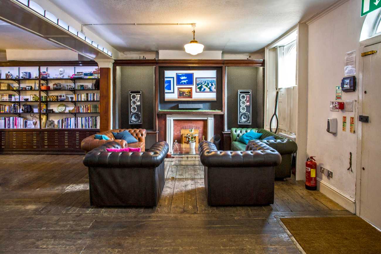Cozy lounge at The Home, Anomalous Space in London, a unique venue hire near me with leather sofas, fireplace, and large speakers, for up to 80 people