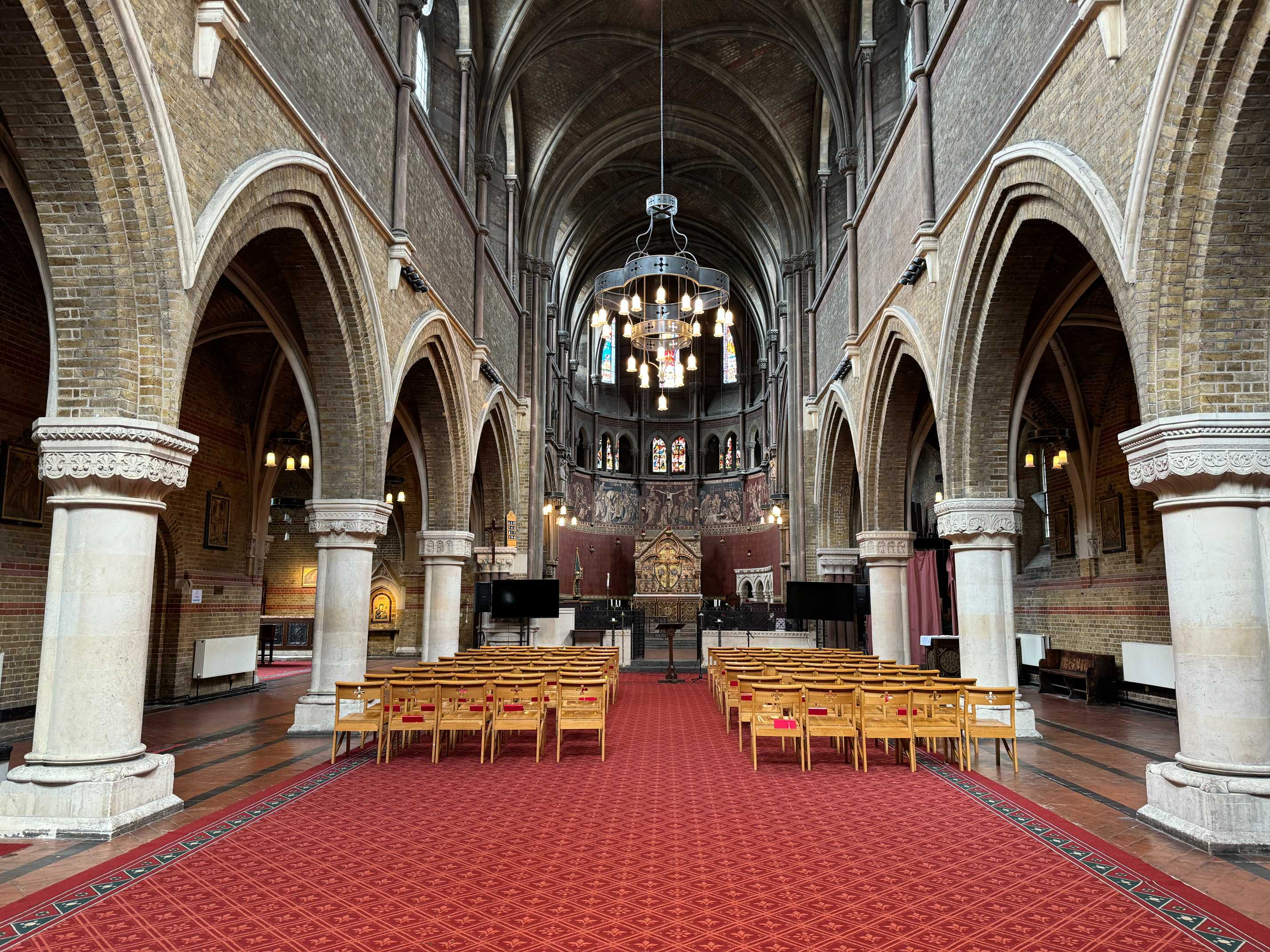 Interior seating view of St Peters Vauxhall showing rows of pews and vibrant stained glass, seating up to 300 guests