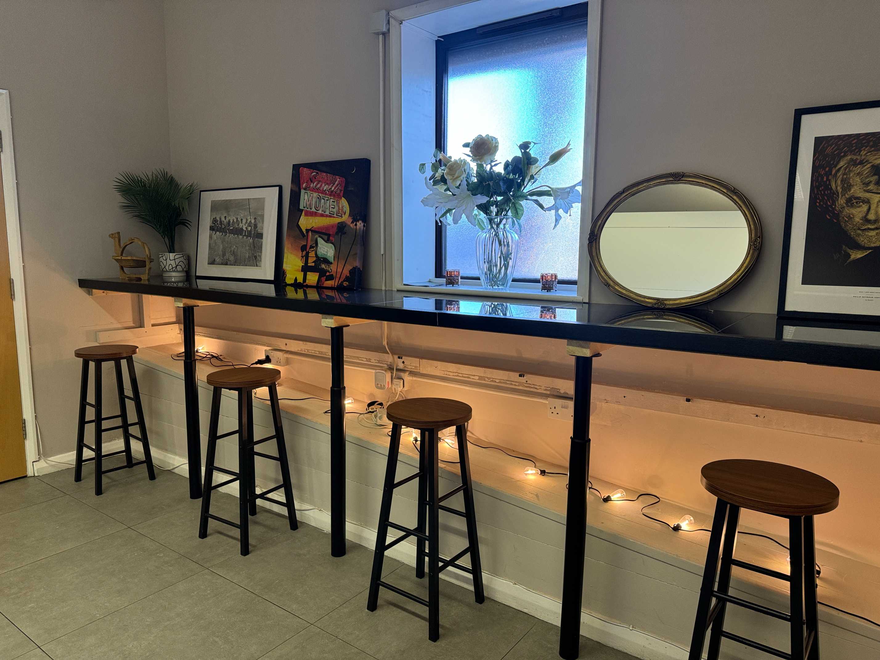 Ambient lighting fills Brixtonia Lounge upstairs, offering a warm and inviting setting for community events.