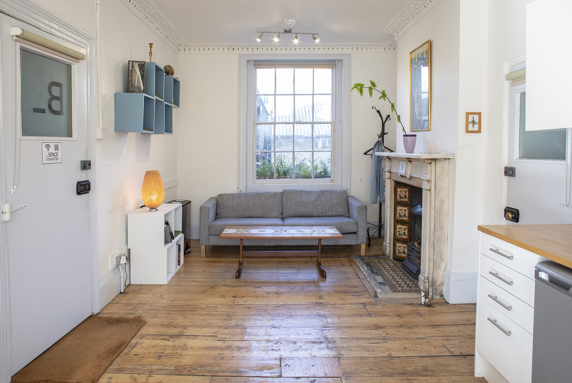 The Office space in Islington, London, a comfy small meeting room hire london with sofa seating, fireplace, and kitchenette area.