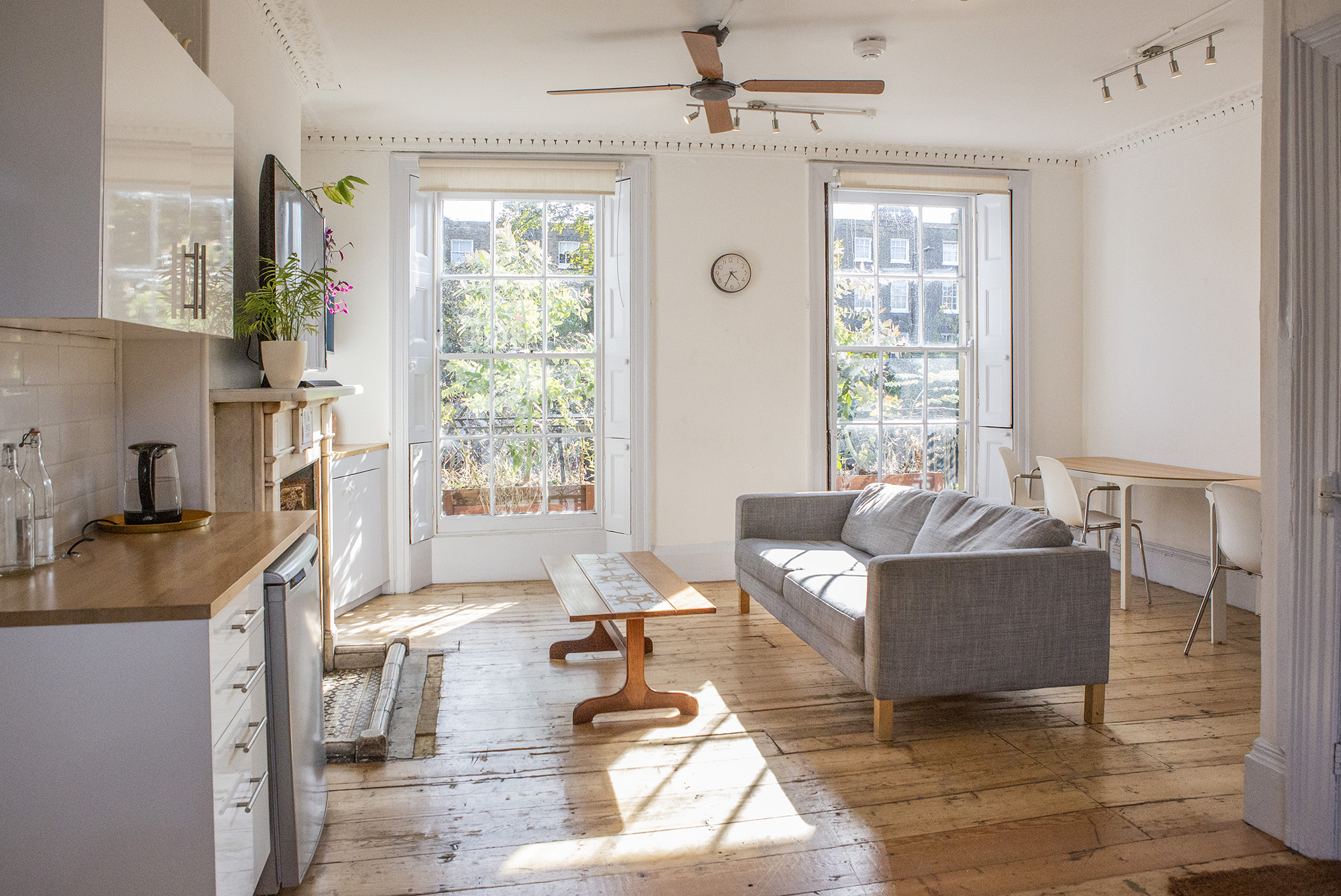Bright small venue hire london at The Office, Anomalous Space, featuring a grey sofa, kitchenette, and great natural light, perfect for 15 guests.