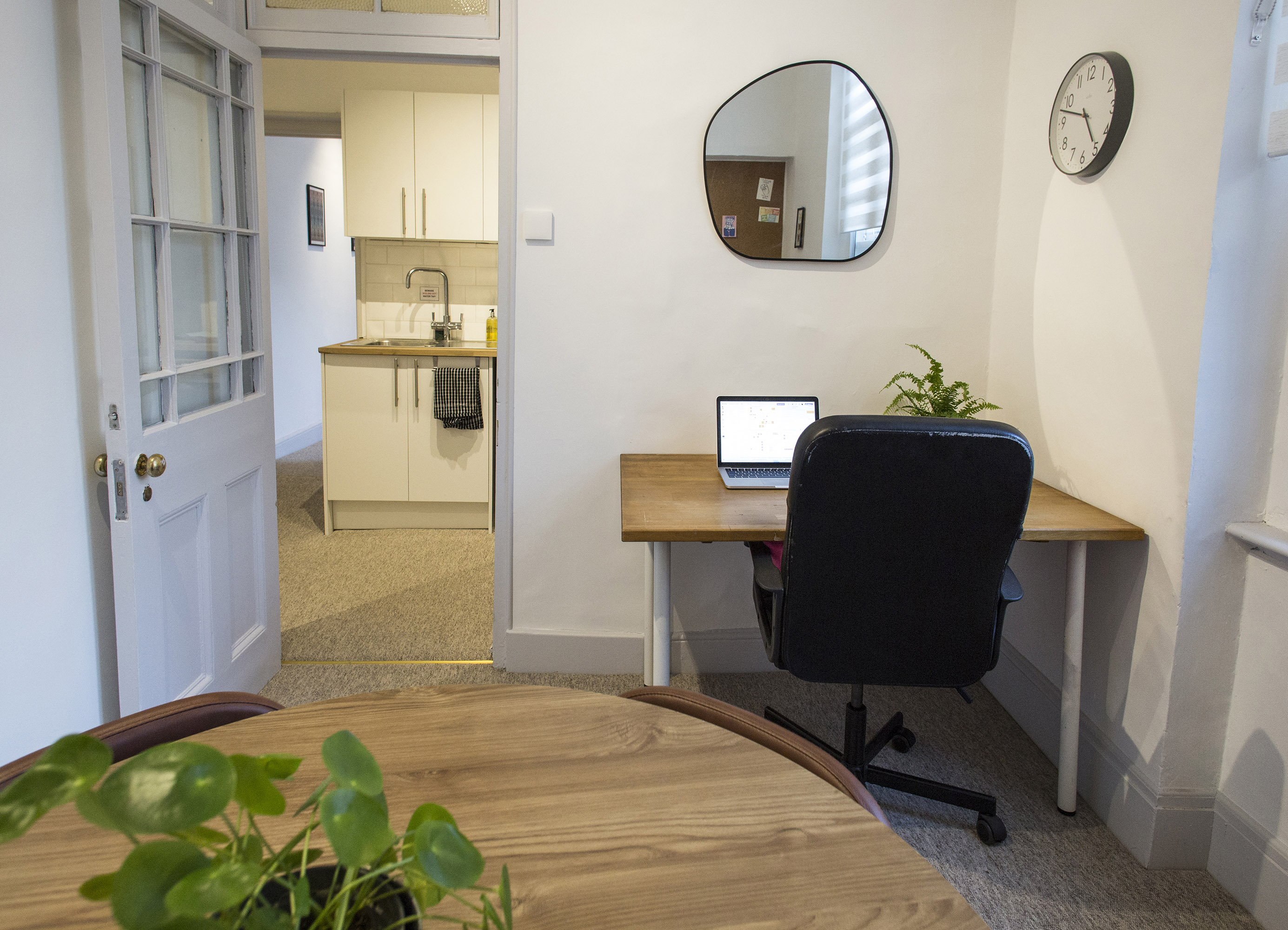 Modern meeting room hire in London at The Flat, Anomalous Space, featuring a small office and kitchenette, ideal for private sessions.