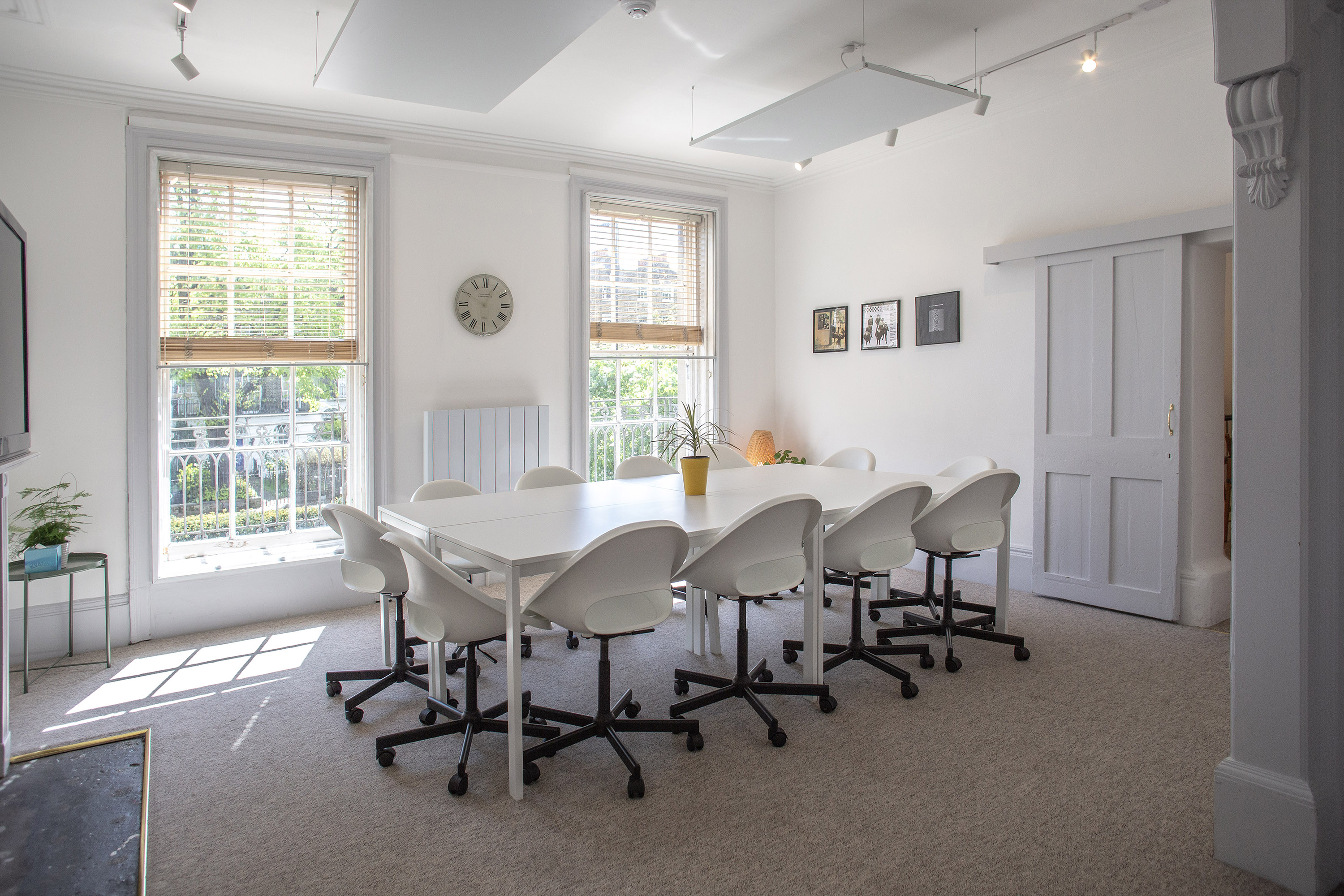 Modern meeting room hire in London at The Flat, Anomalous Space, featuring a clean white table and chairs for effective corporate sessions.