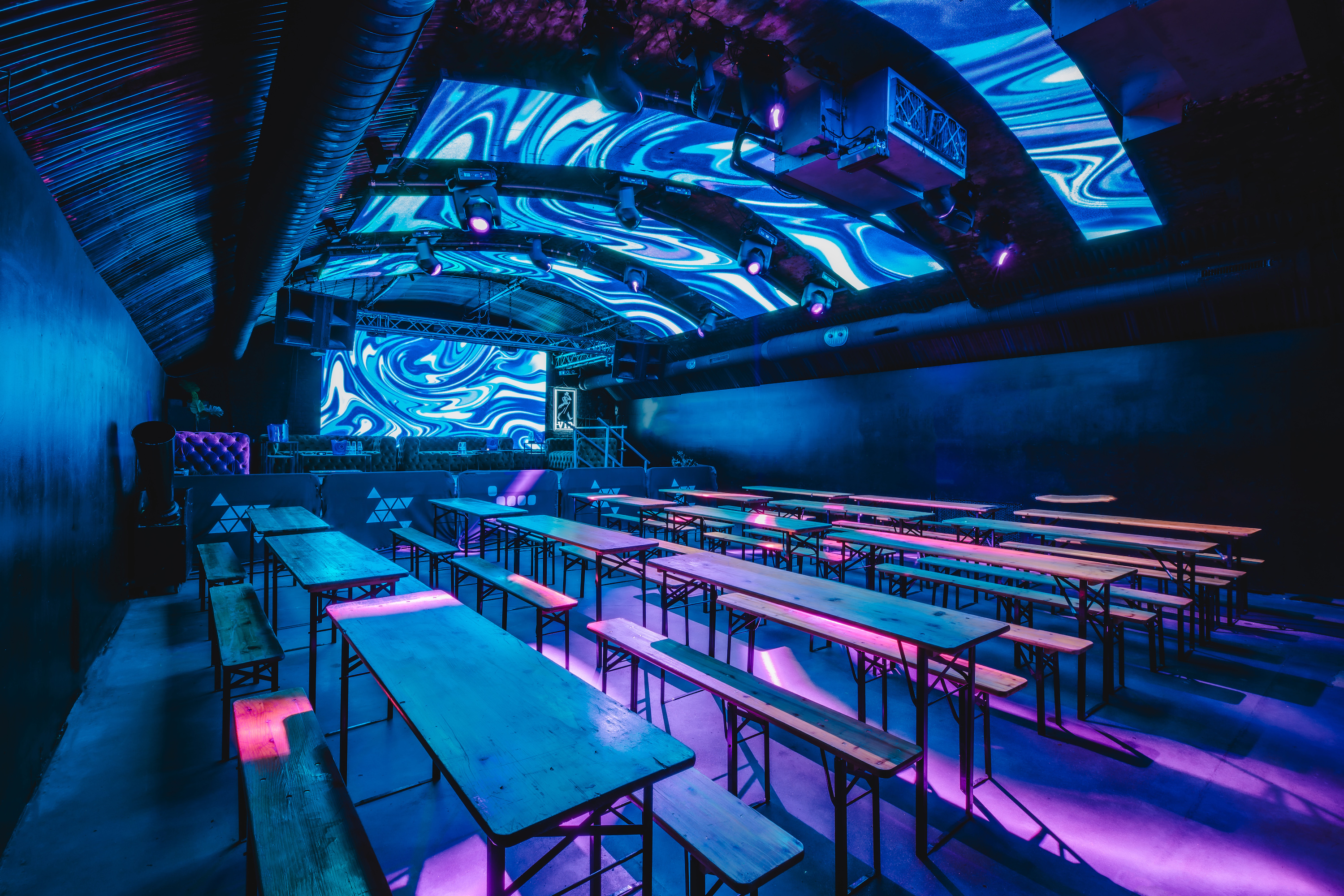 An intimate, warmly-lit bar area at Vauxhall Arches, part of the 600-capacity venue, featuring dark leather booths and polished wooden floors.