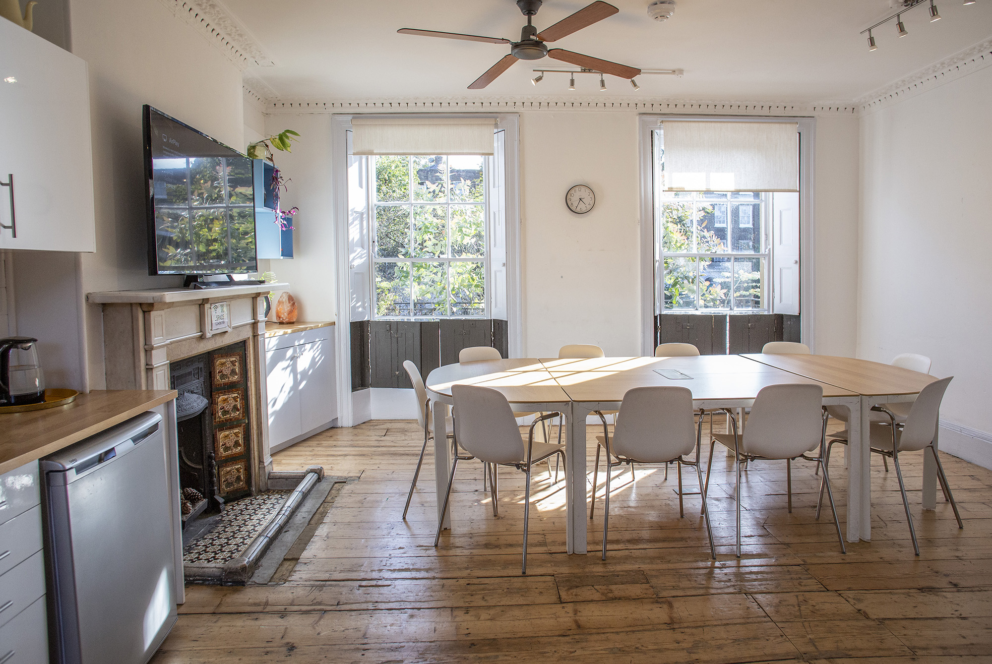 The Office at Anomalous Space in London, a bright meeting room hire in London for 15 guests, featuring a TV and a fireplace.