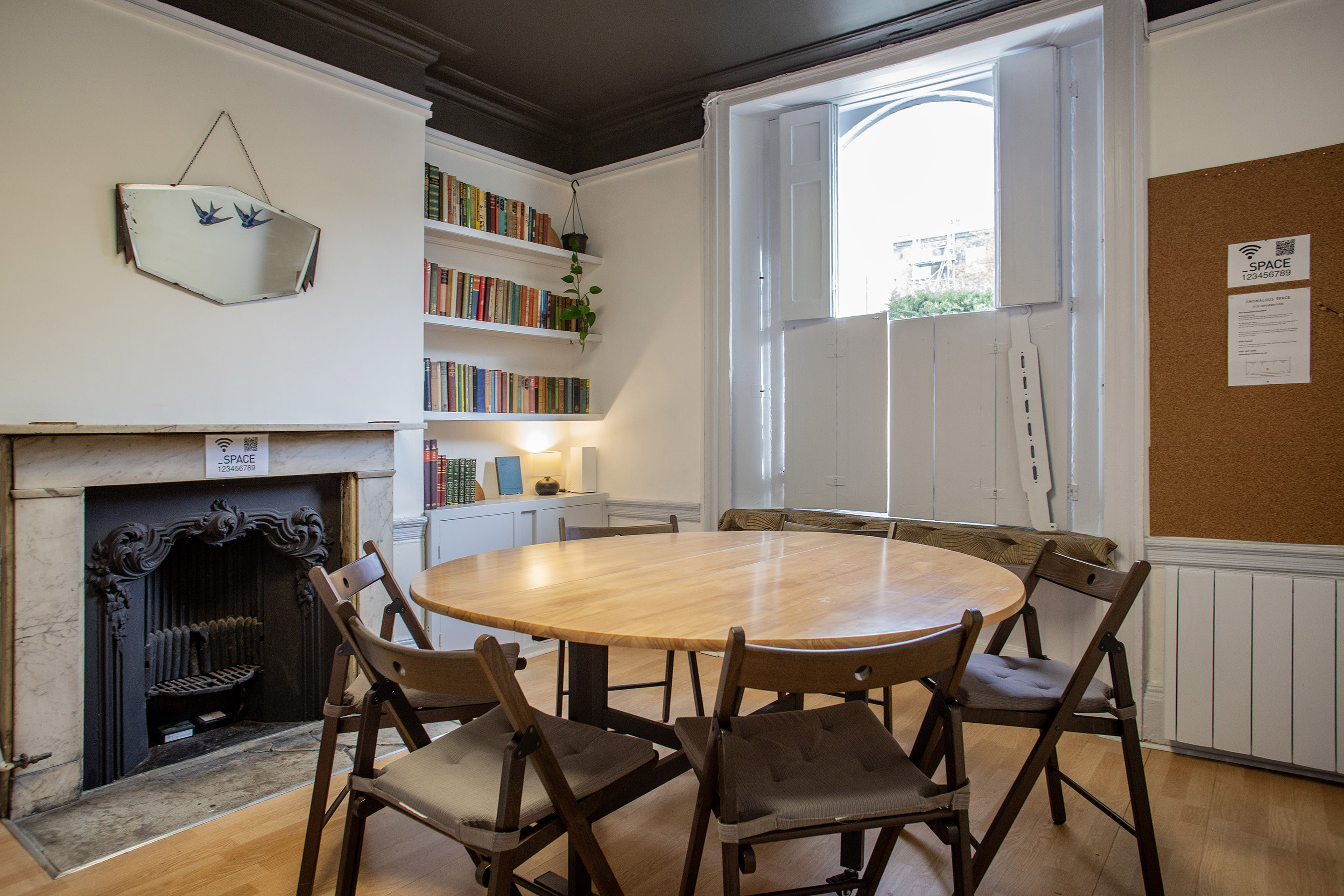 A unique meeting room hire for 10 in Pentonville Rd, London, featuring a fireplace and vintage bookshelf.