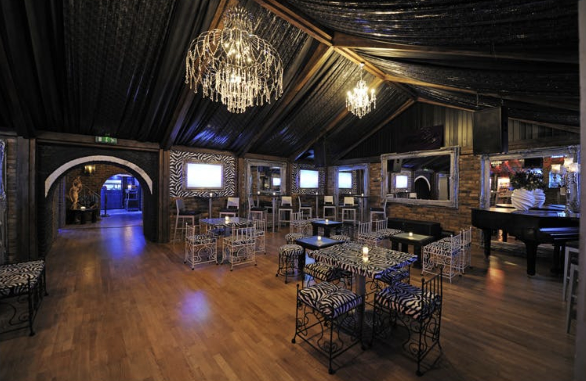 Stylish lounge at Protocol, Vauxhall Arches, for 350, with chandeliers, zebra-print furniture, and arched doorways for events.