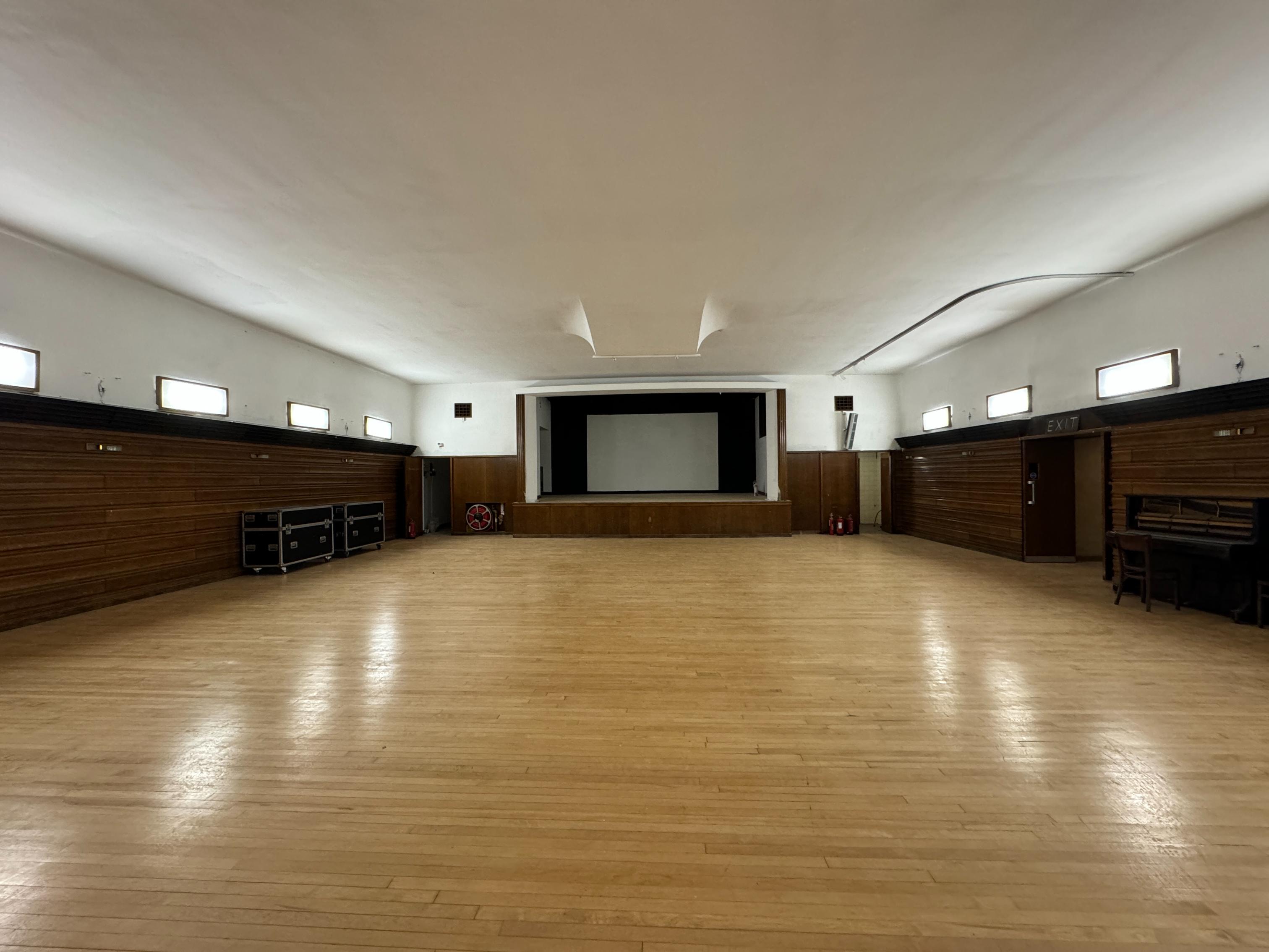 The large, open Minor Hall, highlighting the polished wooden floor and wood-panelled walls from a corner perspective.