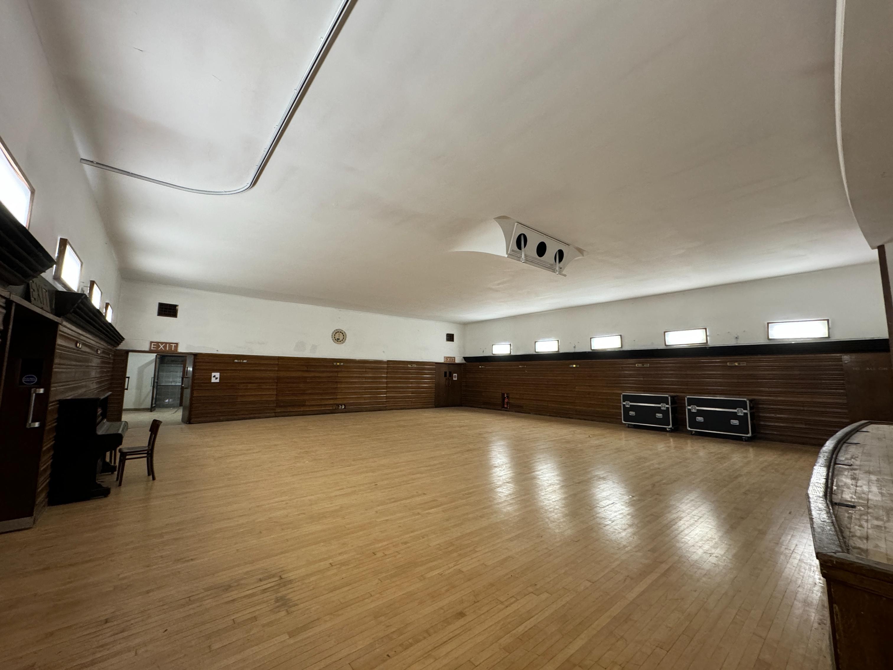 A view of the Minor Hall's wooden floor and panelled walls, as seen from the raised stage area.