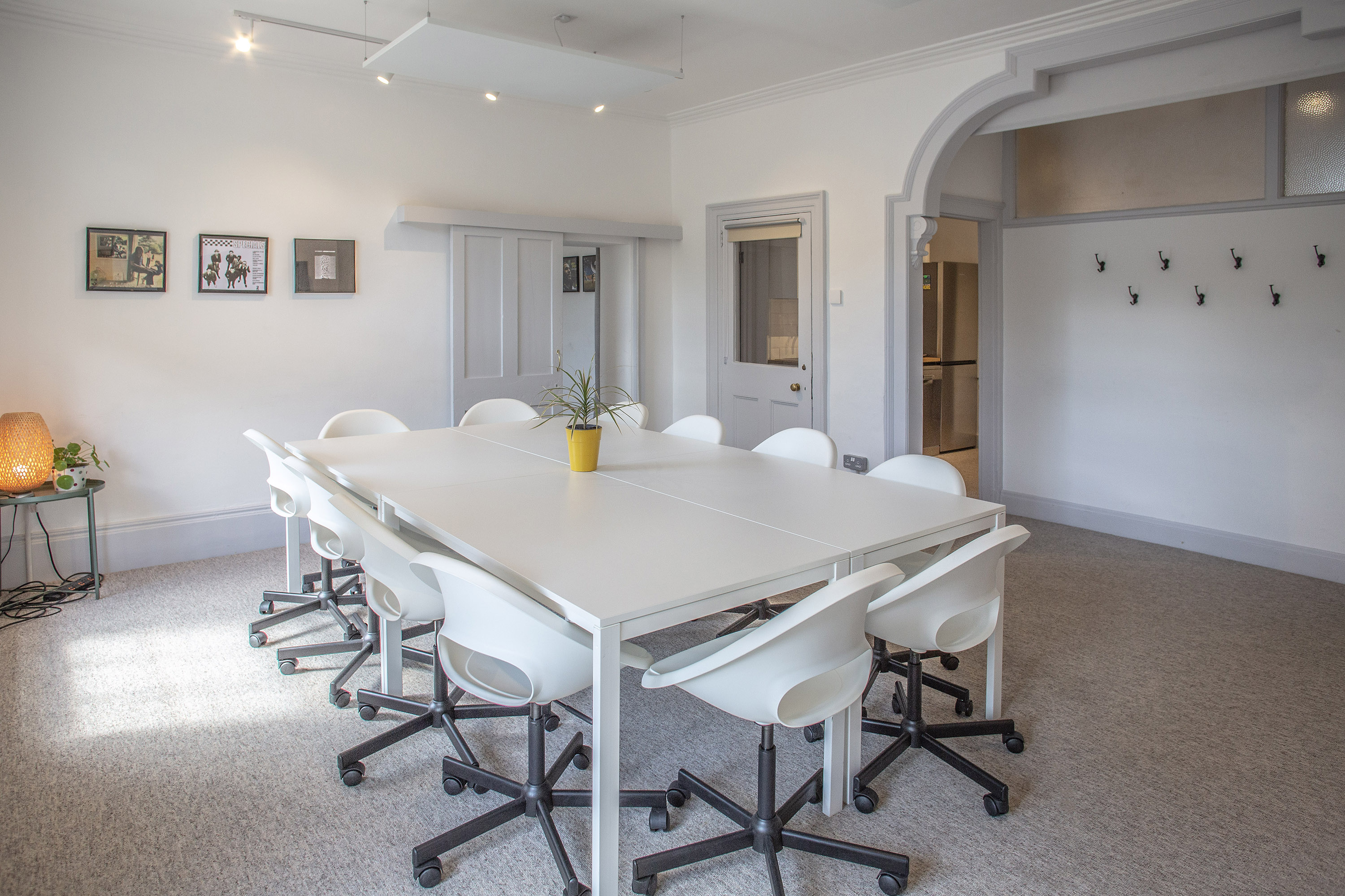 Modern meeting room hire in London at The Flat, Anomalous Space, featuring a large white table and ergonomic chairs, ideal for team discussions.