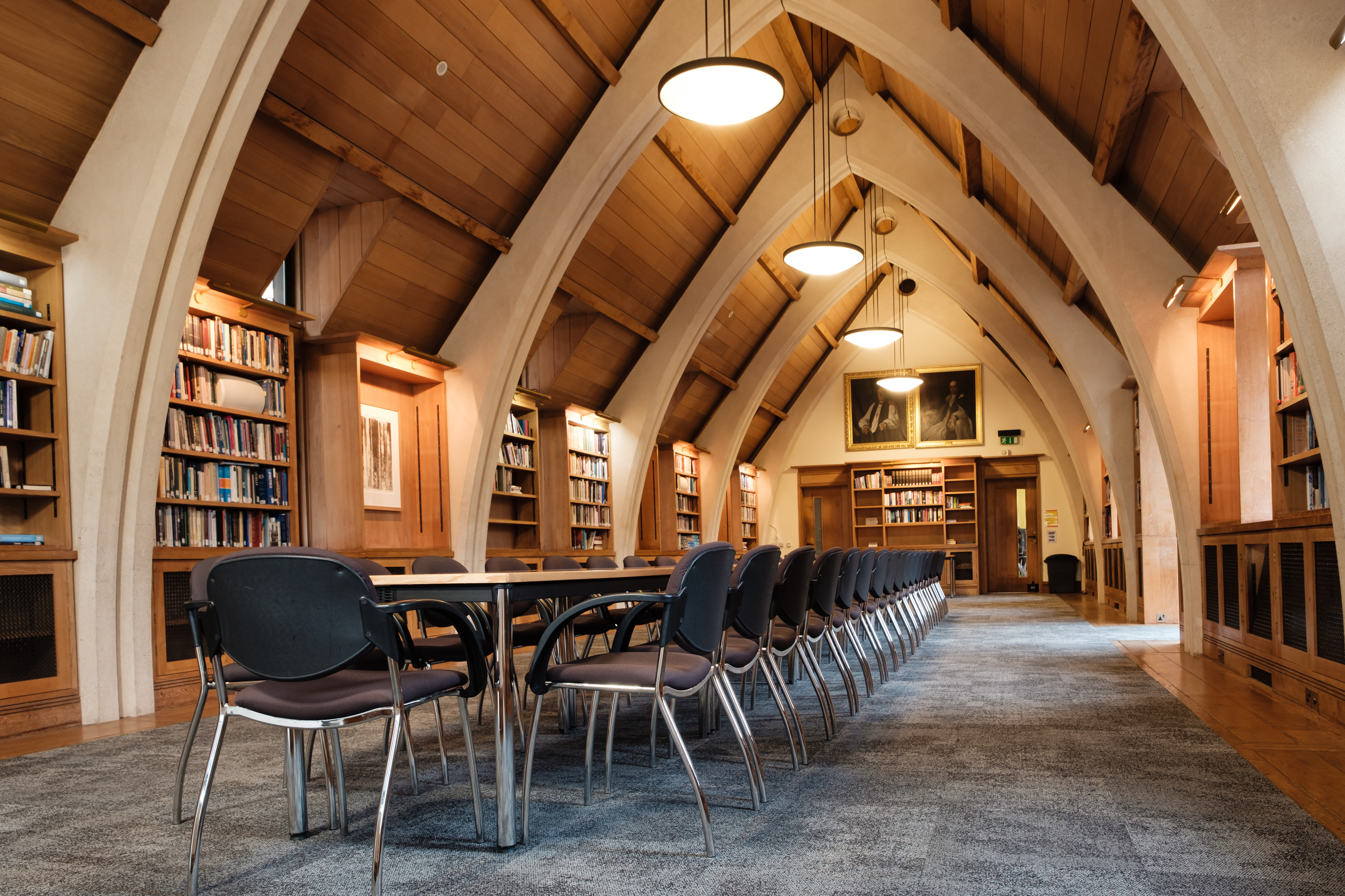 Library interior showing Gothic-inspired design with tables and chairs arranged for a conference or workshop