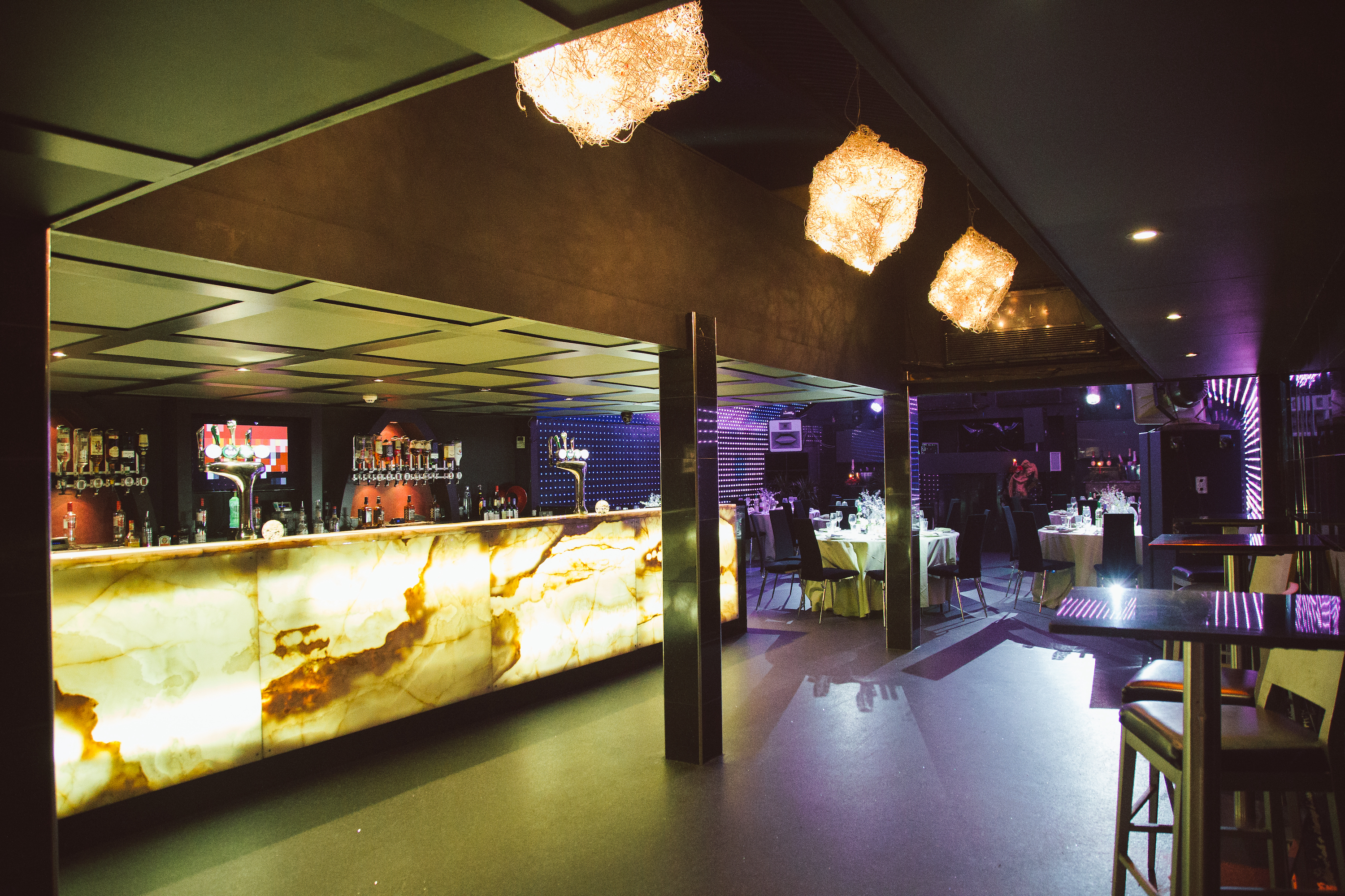 A view from the professional DJ booth at Lightbox, a 150-capacity venue, shows the Pioneer decks surrounded by a vibrant, pulsating orange LED display